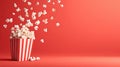 Flying popcorn exploding from a classic red and white striped bucket against a vibrant red background Royalty Free Stock Photo