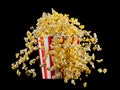 Flying popcorn from striped bucket isolated on black background