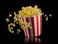 Flying popcorn from striped bucket isolated on black background