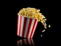 Flying popcorn from striped bucket isolated on black background