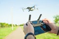 Flying quadcopter drone in the air under blue sky and remote control in the hands Royalty Free Stock Photo