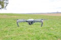 A flying quadrocopter against the background of grass in cloudy weather takes pictures of the surface of the earth Royalty Free Stock Photo