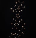 Flying roasted coffee grains on a black background