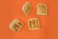 Flying roasted pieces of bread on orange pastel background. Fresh roasted pieces of toasts on orange background. Minimal