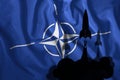 The flying rockets fluttered against the background of the NATO flag in the wind. Symbol, war, conflict