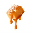 Flying salty caramel candy topped with salt crystals and pouring caramel sauce