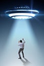 The flying saucer abducting young businessman Royalty Free Stock Photo