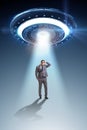 The flying saucer abducting young businessman Royalty Free Stock Photo