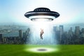 The flying saucer abducting young businessman Royalty Free Stock Photo