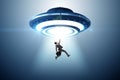 Flying saucer abducting young businessman Royalty Free Stock Photo