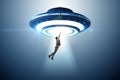 Flying saucer abducting young businessman Royalty Free Stock Photo