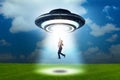 Flying saucer abducting young businessman Royalty Free Stock Photo