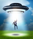 Flying saucer abducting young businessman Royalty Free Stock Photo