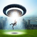 Flying saucer abducting young businessman Royalty Free Stock Photo