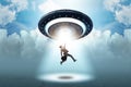 The flying saucer abducting young businessman Royalty Free Stock Photo