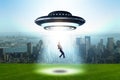 The flying saucer abducting young businessman Royalty Free Stock Photo