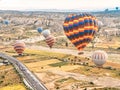 Flying in sky many bright colored beautiful balloons into air in Cappadocia in mountains early at sunrise, dawn. Filling