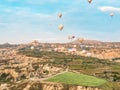 Flying in sky many bright colored beautiful balloons into air in Cappadocia in mountains early at sunrise, dawn. Filling