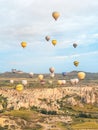 Flying in sky many bright colored beautiful balloons into air in Cappadocia in mountains early at sunrise, dawn. Filling