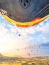 Flying in sky many bright colored beautiful balloons into air in Cappadocia in mountains early at sunrise, dawn. Filling