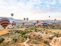 Flying in sky many bright colored beautiful balloons into air in Cappadocia in mountains early at sunrise, dawn. Filling