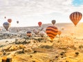 Flying in sky many bright colored beautiful balloons into air in Cappadocia in mountains early at sunrise, dawn. Filling