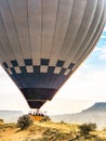 Flying in sky many bright colored beautiful balloons into air in Cappadocia in mountains early at sunrise, dawn. Filling