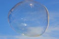 Flying soap bubble with reflection of the blue sky Royalty Free Stock Photo