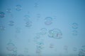 Flying soap bubbles on sky blue background. Royalty Free Stock Photo