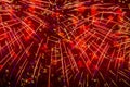 Flying sparks of holiday fireworks, red colored smoke and bright nebula on black sky. Festive vivid background