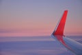 Airplane red wing and winglet, sunrise sky colors