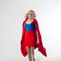 Flying super girl, heroine. Young and beautiful blonde in image of superheroine in red Cape growing