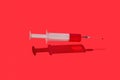 Flying syringe of red blood or liquid with drop on a needle. Royalty Free Stock Photo