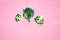 Flying three green broccoli slices on a pink background. Royalty Free Stock Photo