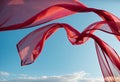 Flying transparent red fabric wave on blue sky background and illuminated by sunlight Royalty Free Stock Photo