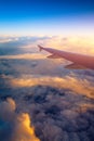 Flying and traveling, view from airplane window on the wing on sunset time. Aircraft wing under the earth and clouds. Flight in Royalty Free Stock Photo