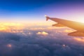 Flying and traveling, view from airplane window on the wing on sunset time. Aircraft wing under the earth and clouds. Flight in Royalty Free Stock Photo