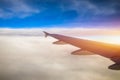 Flying and traveling, view from airplane window on the wing on sunset time. Aircraft wing under the earth and clouds. Flight in Royalty Free Stock Photo