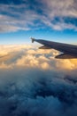 Flying and traveling, view from airplane window on the wing on sunset time. Aircraft wing under the earth and clouds. Flight in Royalty Free Stock Photo