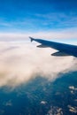 Flying and traveling, view from airplane window on the wing on sunset time. Aircraft wing under the earth and clouds. Flight in Royalty Free Stock Photo