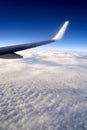 Flying and traveling. View of airplane wing on blue sky background. Plane over clouds in the sky. Royalty Free Stock Photo