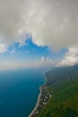 Flying under the clouds along the turquoise sea and the green coast with many hotels. aerial photo from a paraglider, summer Royalty Free Stock Photo