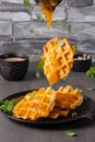 Flying waffles and mint getting dropped with mango jam a grey background Royalty Free Stock Photo