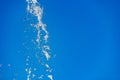 Flying water drops on blue background Royalty Free Stock Photo