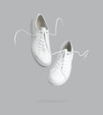 Flying white leather womens sneakers isolated on gray background. Fashionable stylish sports casual shoes. Creative minimalistic Royalty Free Stock Photo