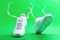 Flying white sneaker Nike on green background. Fashionable stylish leather sports casual shoes