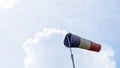 Flying windsock wind vane with red, white and blue lines on dramatic sky background. Space for text Royalty Free Stock Photo