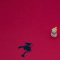 Flying witch and snowman toys on red surface with copyspace