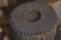 Flywheel old on a wooden stump in the workshop. Royalty Free Stock Photo