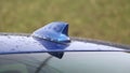 FM AM GPS radio antenna in the form of a shark fin on the roof of a blue car